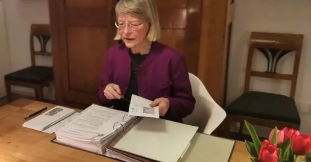 Elisabeth sortiert Post in einen Ordner