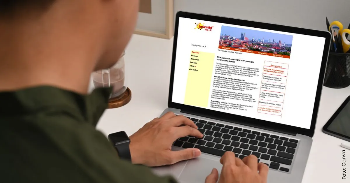 Mann sitzt am Laptop und tippt, overshoulder