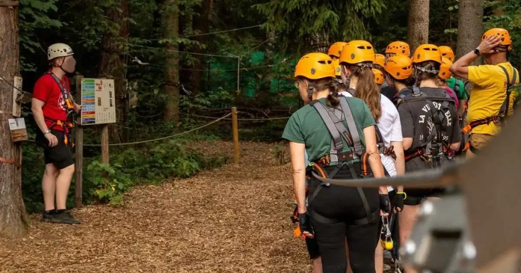 gruppe menschen erhalten einfürhung im kletterwald