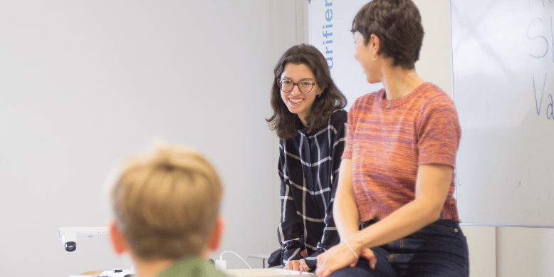 Frau steht an einem Whiteboard und erklärt