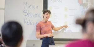 Frau steht an einem Whiteboard und erklärt